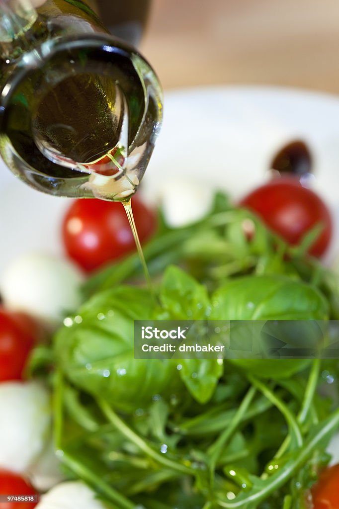 Dressing verser de l'huile d'Olive sur la salade fraîche - Photo de Aliment libre de droits