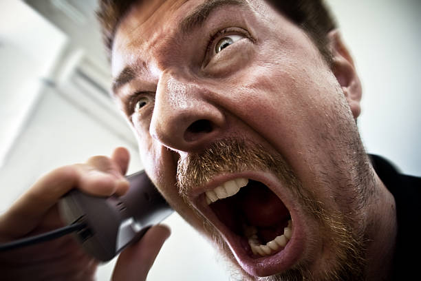 Man shouting at telephone stock photo