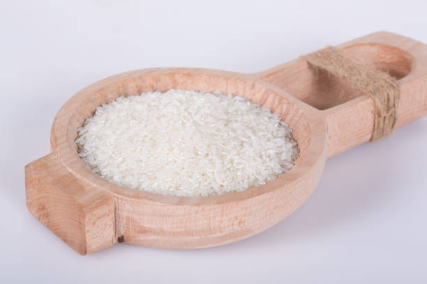 istock Raw rice in a wooden spoon is stack up 974865404