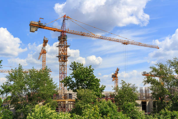 istock High-rise cranes at the construction site against blue sky 974868120