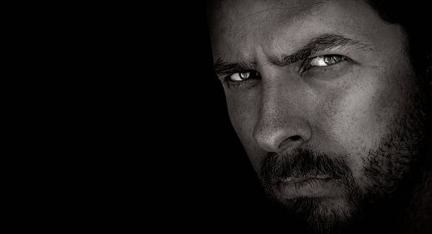 Dark portrait of scary man with evil eyes stock photo