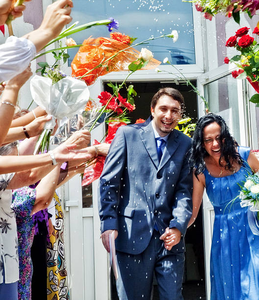 Marriage celebration - husband wife rice and flowers stock photo