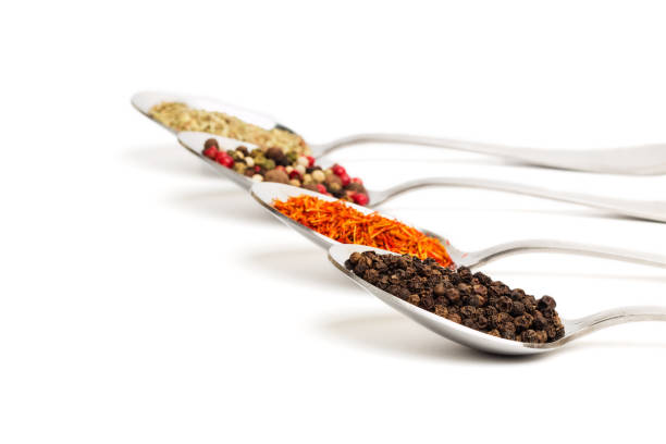 istock Different spices in iron spoons isolated on white 974870570