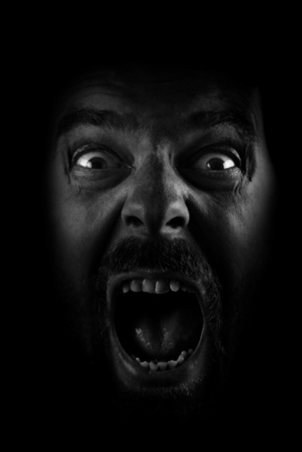 portrait of man shouting with open mouth. Lateral light was used. Photographed in a dark environment. It was shot in a studio environment with a full frame camera.