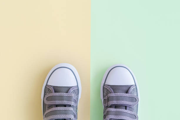 istock Grey kids sneakers on yellow green background 974874882