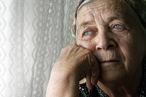 Sad lonely pensive old senior woman stock photo