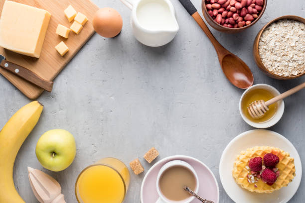 istock Healthy Breakfast Cheese Juice coffee Honey Peanuts Egg Biscuits Waffles Cereal Oatmeal Apple Banana. Selective focus. The view from the top. Flat position 974880994
