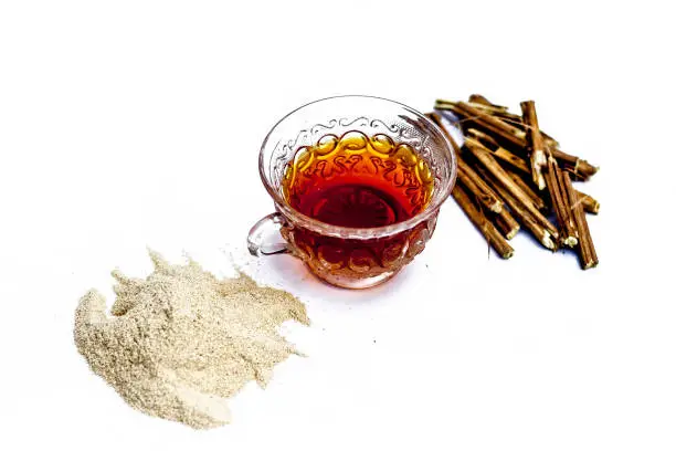 Ashwagandha roots and its powder also known as Indian ginseng, isolated on white essential beneficial for hair loss with its organic tea made from its powder.