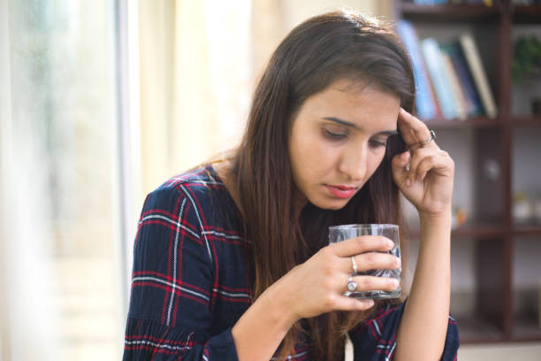 istock Sick woman drinking water 974891548