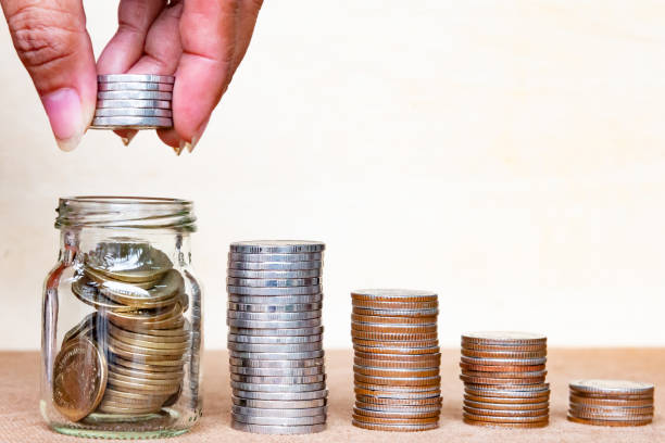 istock Saving money concept. Close up hold stack coins to arrange inger hold stack coins into bottle arrangement with shown concept of growing business and wealthy. 974895300