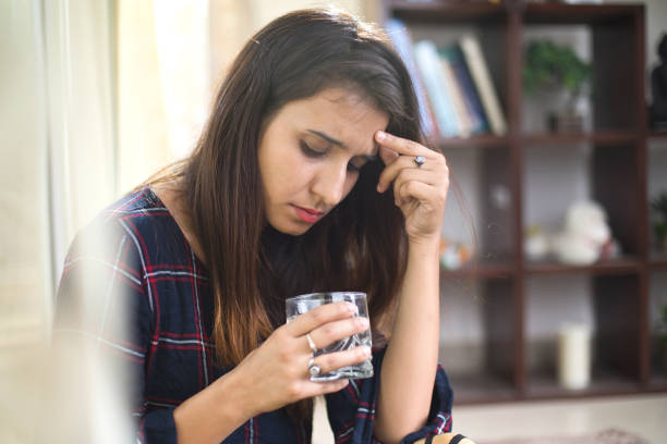 istock Sick woman drinking water 974898512