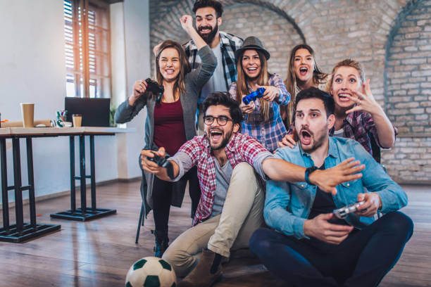 istock Coworkers playing video games in office 974902962