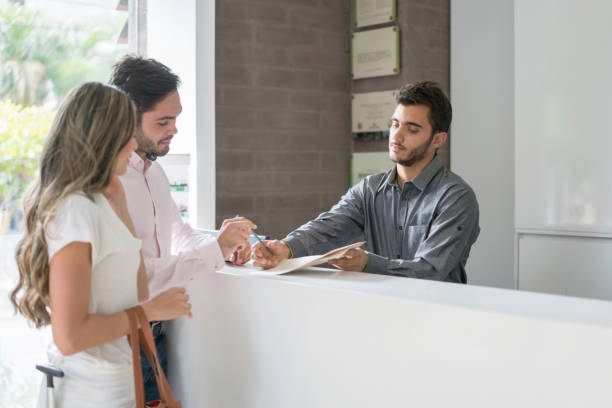 istock Happy couple doing the check-in at a hotel 974905292