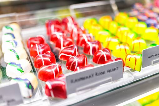 Macro closeup of creative colorful shapes from candy shaped hearts on display in confectionery chocolate store shop