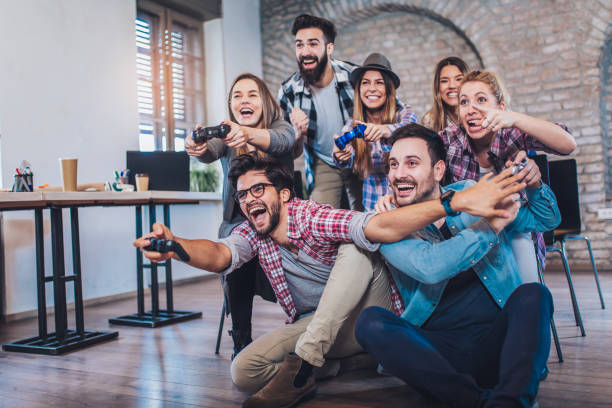 istock Coworkers playing video games in office 974908198