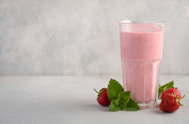 istock Strawberry milkshake on a gray concrete background. 974910184