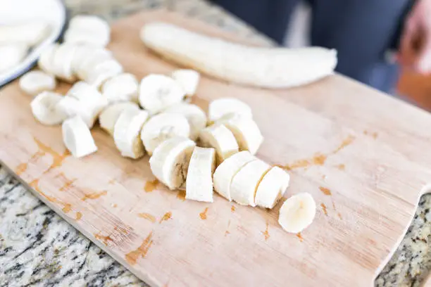 Photo of Chopped frozen banana on wooden bamboo chopping board closeup