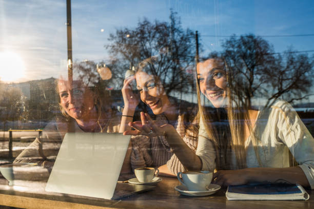istock Female students looking something on laptop in cafeteria. 974916990