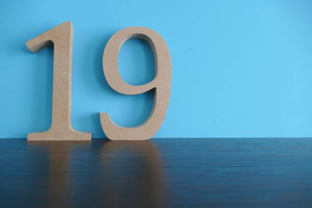 istock Number 19 in wooden numbers on blue background 974922092