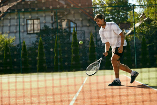 istock Man Playing Tennis Outdoors. 974922448
