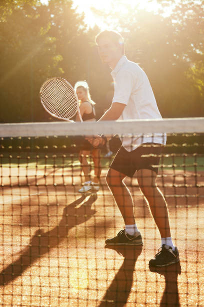 man and woman playing tennis on court. - tennis couple women men imagens e fotografias de stock