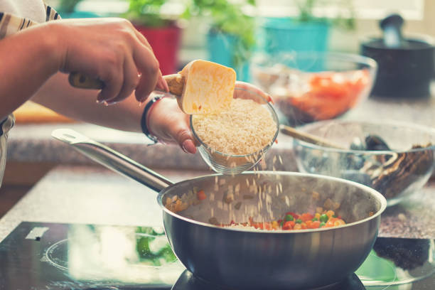 istock Young Woman Preparing Paella 974943078