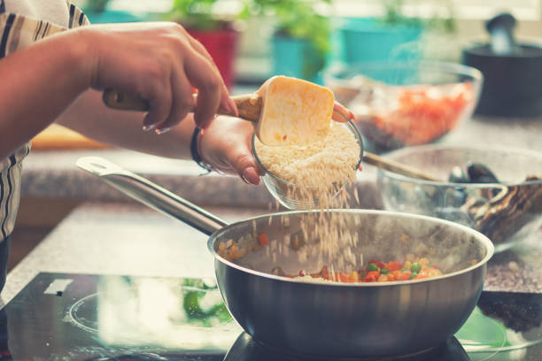 istock Young Woman Preparing Paella 974943350