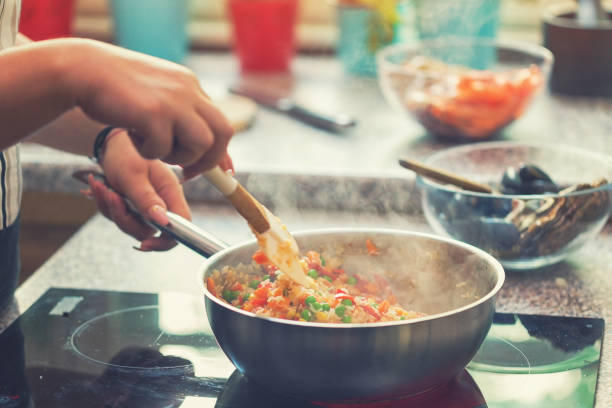 istock Young Woman Preparing Paella 974944024