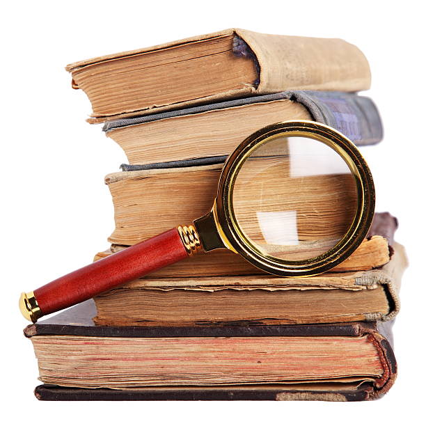 Books and magnifying glass isolated on white