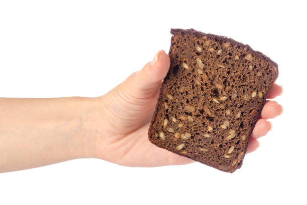 istock A piece of bread with seeds in a hand 974947504