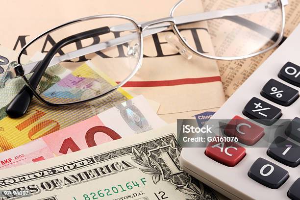 Calculator Glasses And Currencies On A Newspaper Stock Photo - Download Image Now - Business, Calculator, Chinese Yuan Note