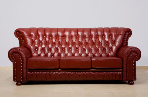 3D render of Red fabric sofa with pillows isolated on dark background.