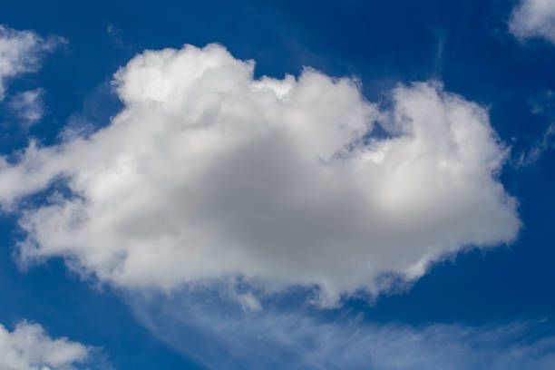 istock White fluffy clouds in the blue sky background 974967114