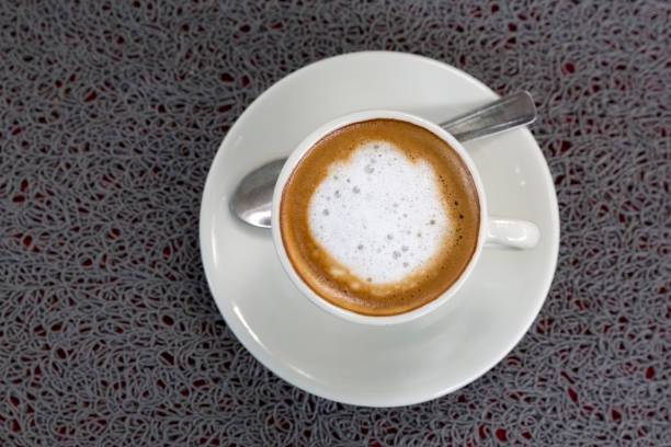 istock Cup of white coffee with spoon 974967322