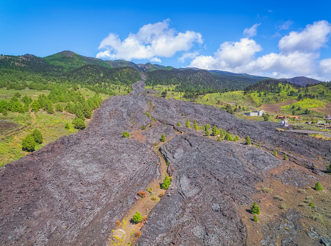 The San Juan volcano erupted along a four-kilometer-long eruption fissure at three points on the crest of the Cumbre Vieja of the Canary Island of La Palma between June 24 and July 30, 1949. The three eruptions were of different volcanological characteristics, the newly formed Duraznero crater, the Llano del Banco eruption column and the Hoyo Negro blast crater. Between the towns of Todoque, Las Manchas and Puerto Naos, the extensive lava field is visible, which is crossed by the connecting roads between the towns.