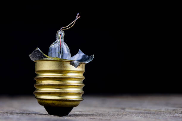 Damaged light fixture mounted on a white concrete ceiling