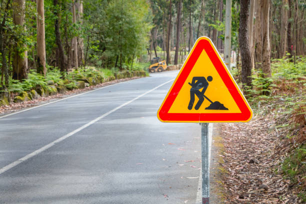 temporary road sign indicating work on a small road in the forest