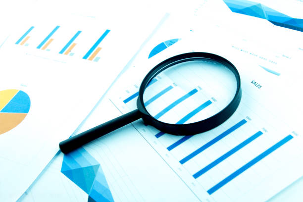 istock Business Analysis and Statistics Reports from sales charts last year using a magnifying glass. 974969514