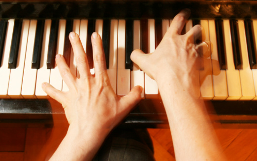 A pair of children's hands playing the piano