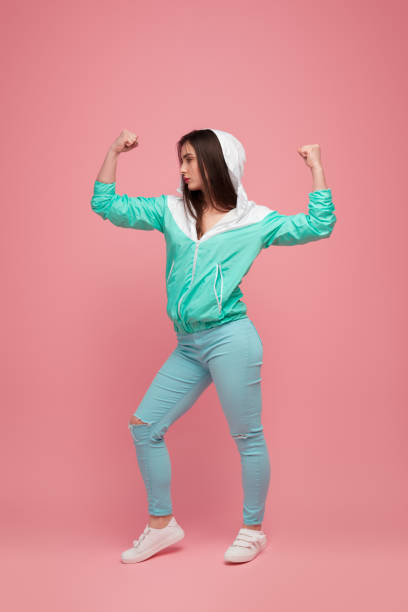 istock Strong woman in blue outfit on pink 975002548