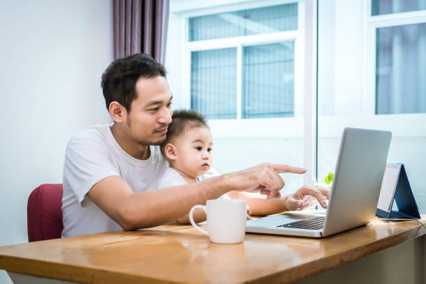istock Single dad and son using laptop together happily. Technology and Lifestyles concept. Happy familly and baby theme. 975023738