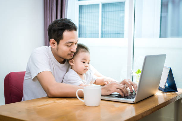 istock Single dad and son using laptop together happily. Technology and Lifestyles concept. Happy familly and baby theme. 975023742