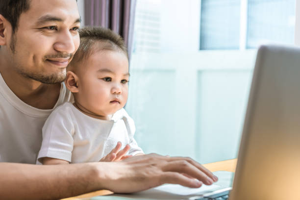 istock Single dad and son using laptop together happily. Technology and Lifestyles concept. Happy familly and baby theme. 975023752