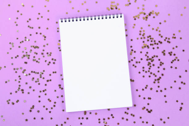 istock An empty pad on a pastel background surrounded by shiny decorative stars and balls. 975025936
