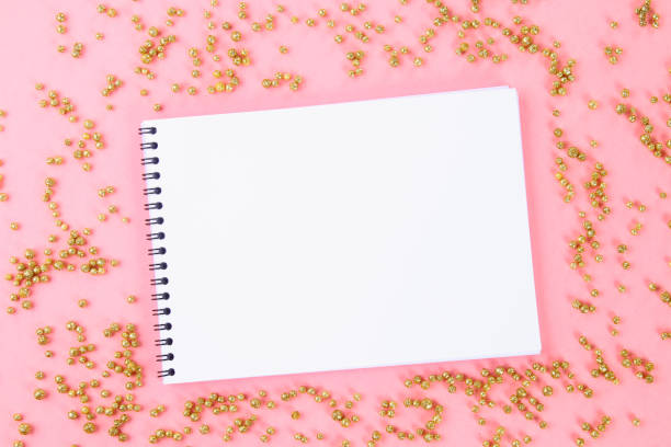 istock An empty pad on a pastel background surrounded by shiny decorative stars and balls. 975026068