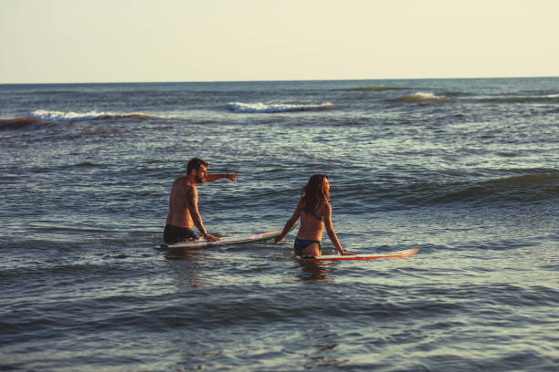 istock Man and woman surfers chasing waves 975027284