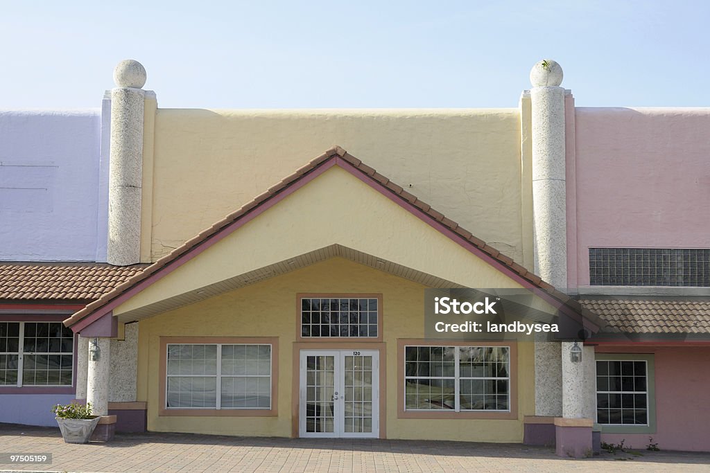 Renovated store front Pastel colors, pillars, terracotta style roof and brick sidewalks have been added to this older building to attract retailers and shoppers Strip Mall Stock Photo