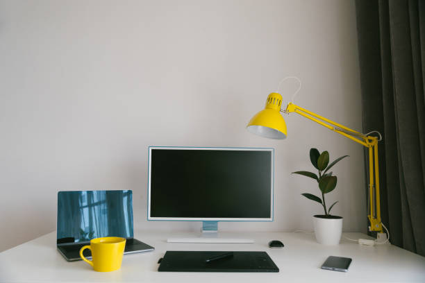 istock workplace. white desk with laptop and yellow cup. designer working place 975086302