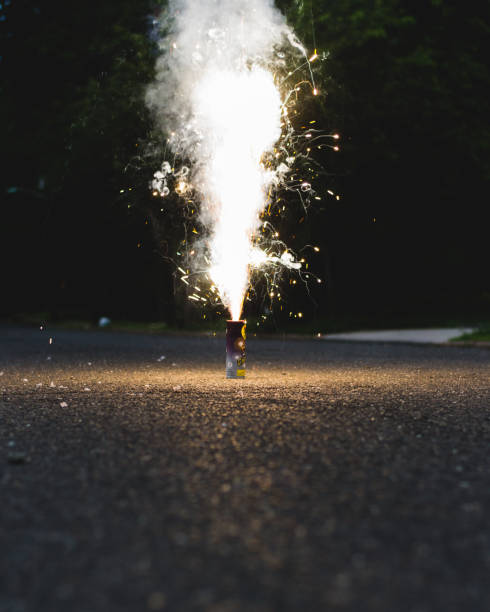 Fireworks exploding on a street Small novelty cake fireworks exploding on a quiet street firework explosive material photos stock pictures, royalty-free photos & images