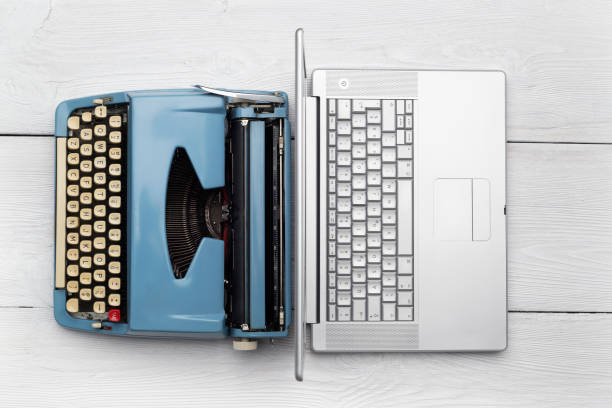 istock Modern Laptop Computer with Antique Typewriter on wooden desk 975088774
